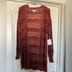 Orange cardigan from Kohls. Large, flowing down past hips. Lightweight.